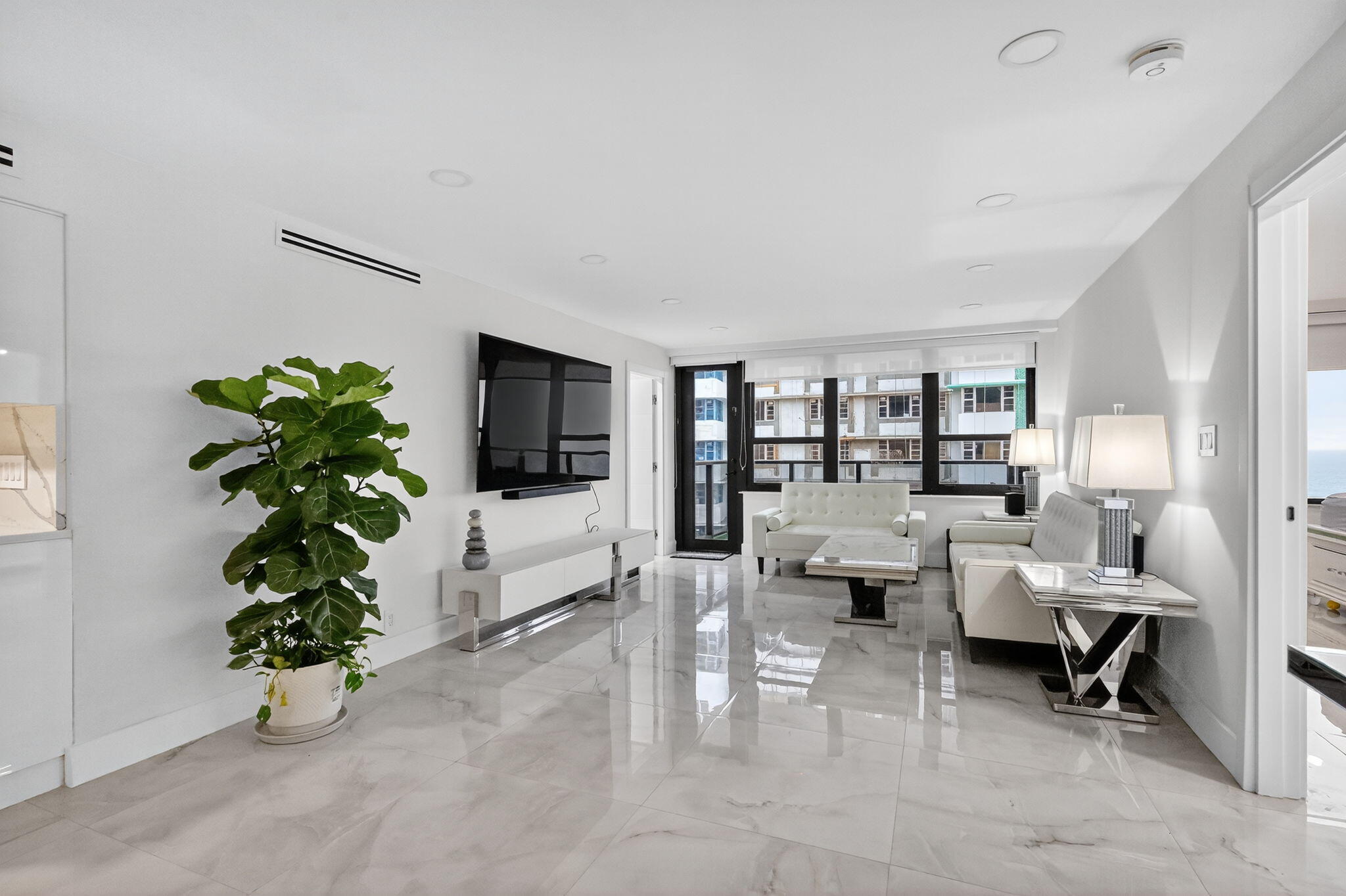 5225 Collins Avenue, Unit 1408 Miami Beach, FL 33140 - Photo 2 of 37 a living room with furniture potted plant and a window