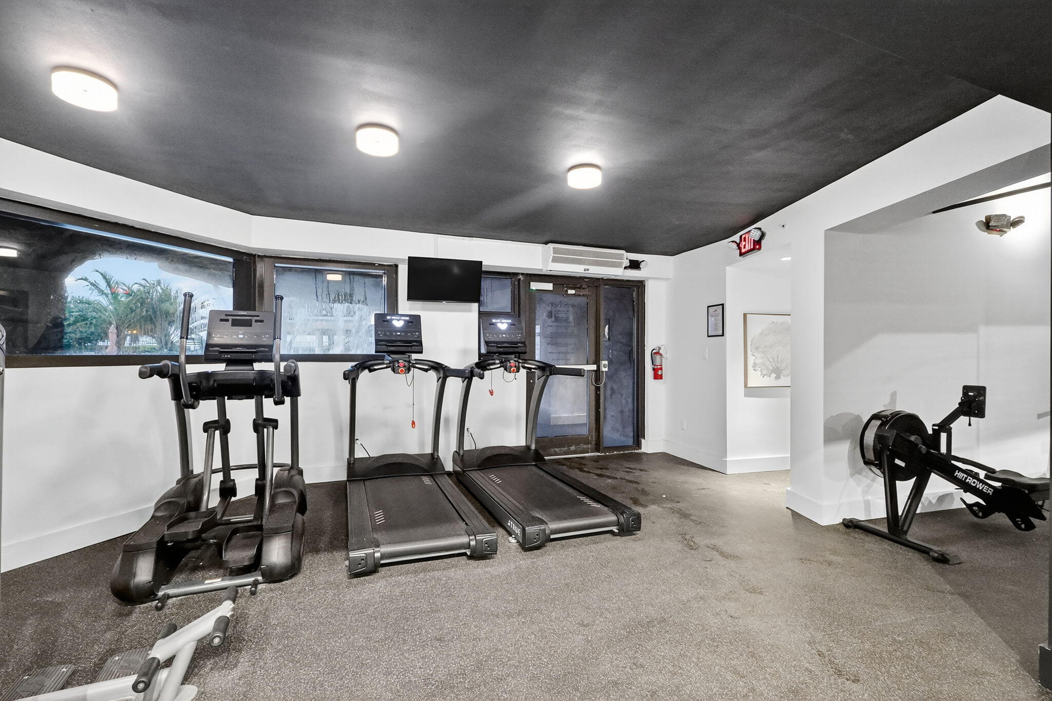 5225 Collins Avenue, Unit 1408 Miami Beach, FL 33140 - Photo 31 of 37 a room with gym equipment and large mirror