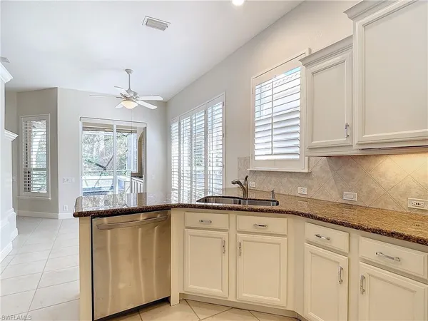 a kitchen with granite countertop white cabinets and a sink