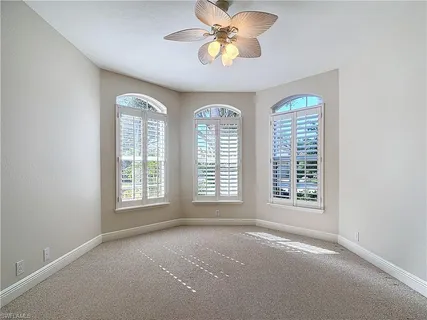 an empty room with a window and a fan