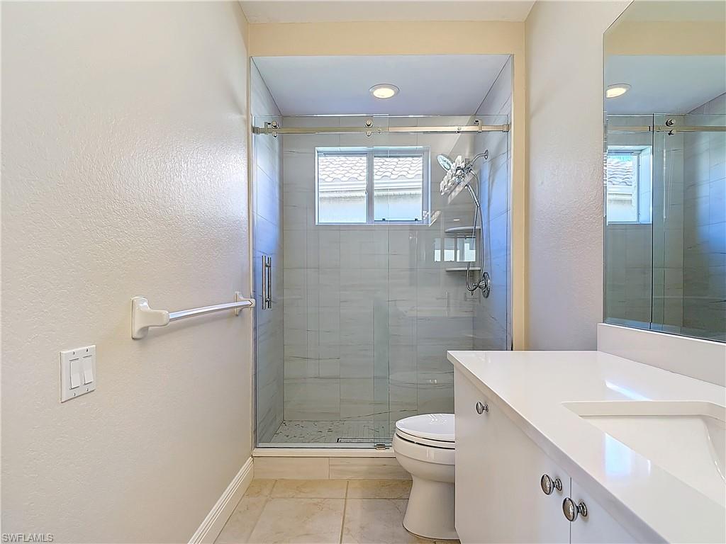 9190 Troon Lakes Drive Naples, FL 34109 - Photo 25 of 50 a bathroom with a sink a toilet and shower