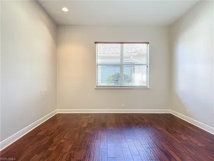 a view of a room with wooden floors and window