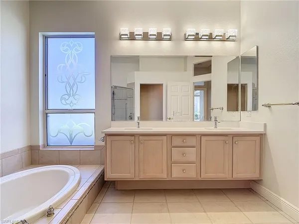 a spacious bathroom with a tub sink and mirror