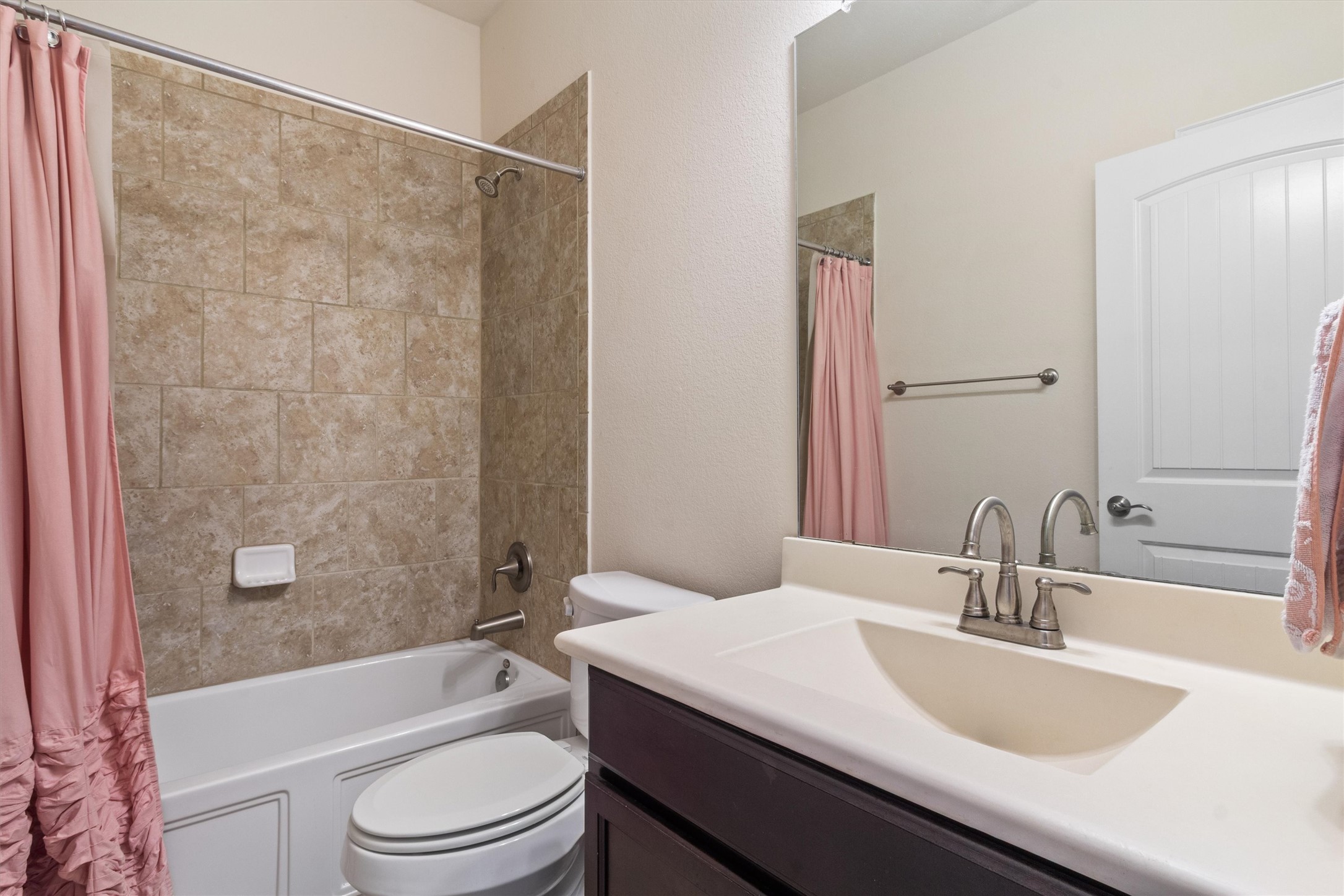 10413 Crescendo Lane Austin, TX 78747 - Photo 20 of 32 Tiled shower and a modern vanity await in this functional bathroom space.