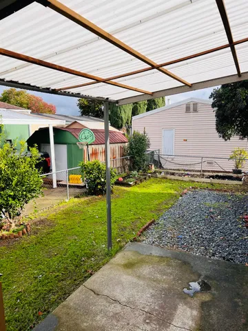 a view of a house with backyard and sitting area