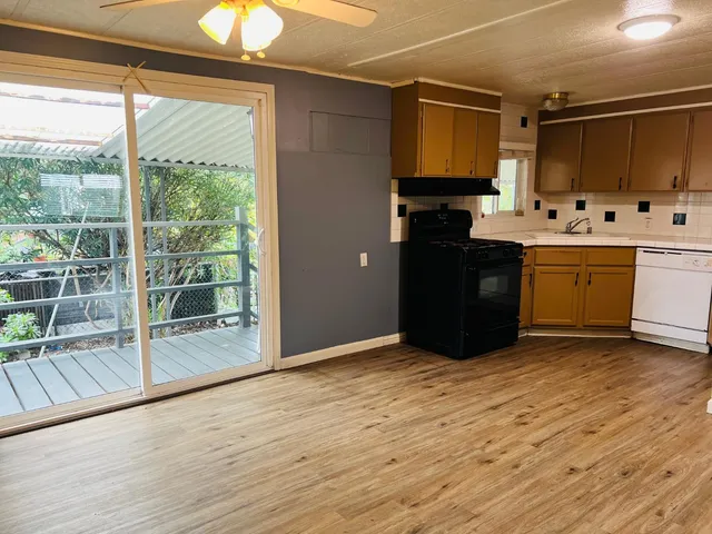 a kitchen with granite countertop a stove and a wooden floors
