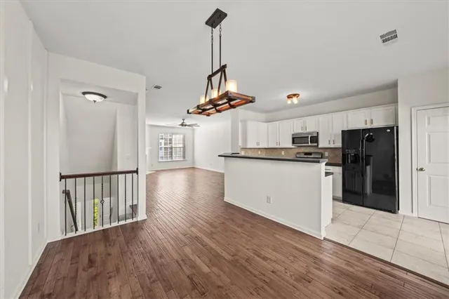 a view of a kitchen with refrigerator and white walls
