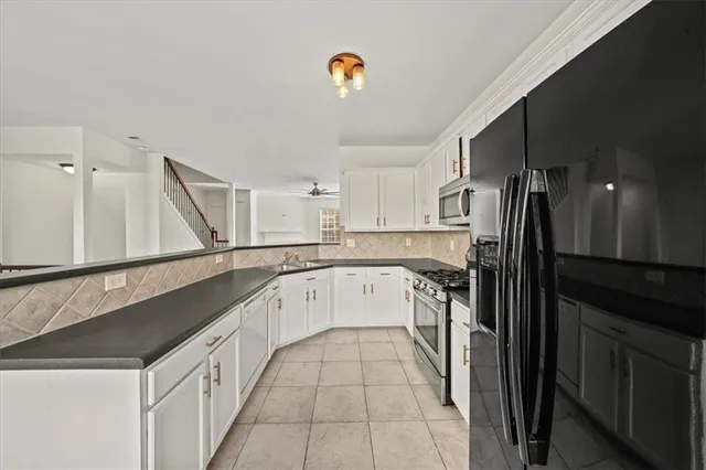 a kitchen with granite countertop a refrigerator stove and sink