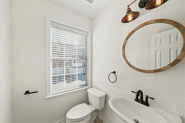 an empty room with a chandelier fan and windows