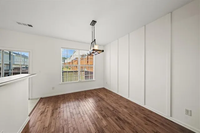 a kitchen with stainless steel appliances granite countertop a refrigerator a stove a sink dishwasher and white cabinets with wooden floor