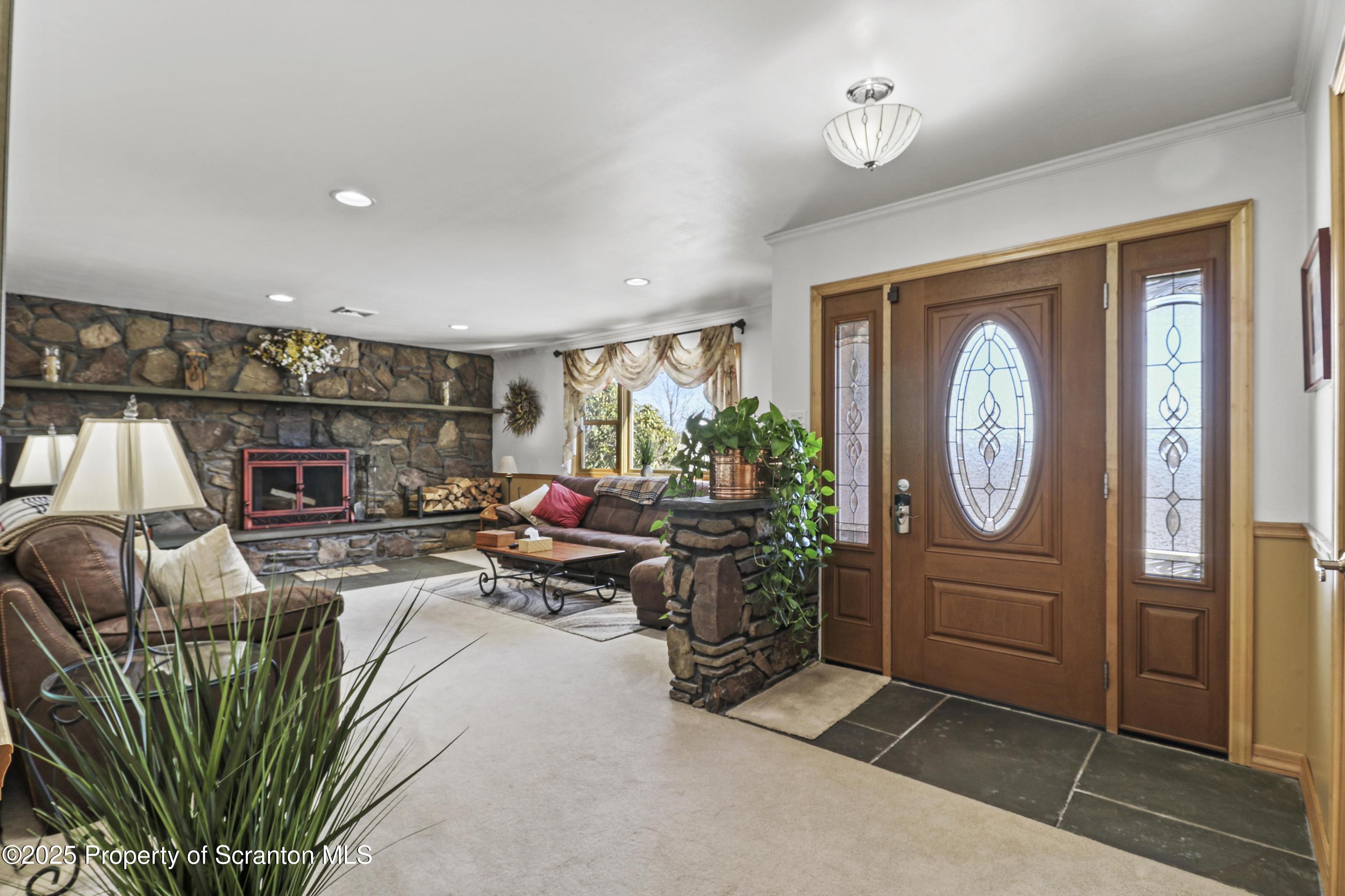 337 Ross Road Dalton, PA 18414 - Photo 5 of 45 a living room with furniture a fireplace and a potted plant