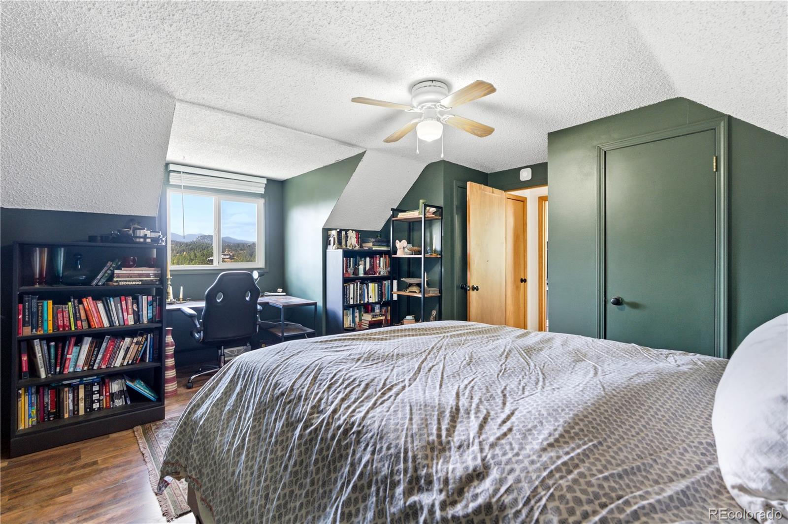 243 Hi Meadow Drive Bailey, CO 80421 - Photo 24 of 37 a bedroom with a large bed and a chandelier