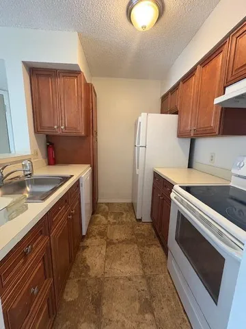 a kitchen with a sink stove and refrigerator