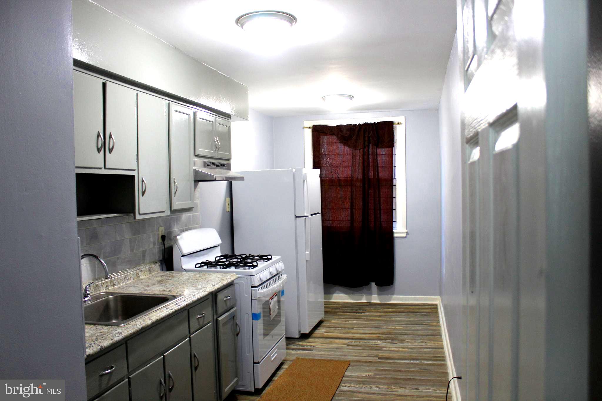 565 East Tabor Road Philadelphia, PA 19120 - Photo 3 of 20 a kitchen with stainless steel appliances granite countertop a refrigerator and a sink