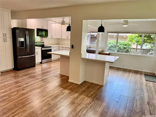 a kitchen with stainless steel appliances wooden floors and wooden cabinets
