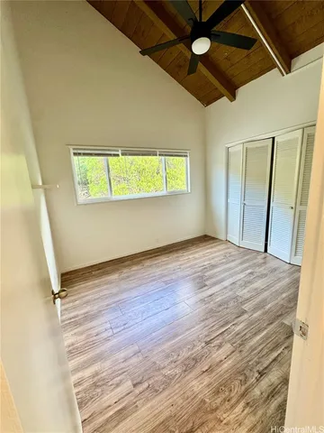 a view of empty room with wooden floor and fan