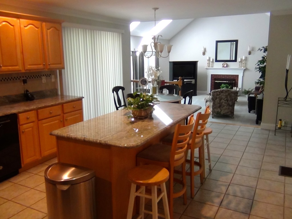 49 Hudson Road Bolton, MA 01740 - Photo 5 of 30 a kitchen with a table chairs and a fireplace