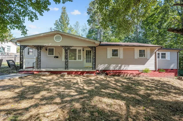 a backyard of a house with table and chairs