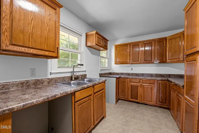 a view of kitchen with stainless steel appliances granite countertop a stove a sink dishwasher a refrigerator and a window