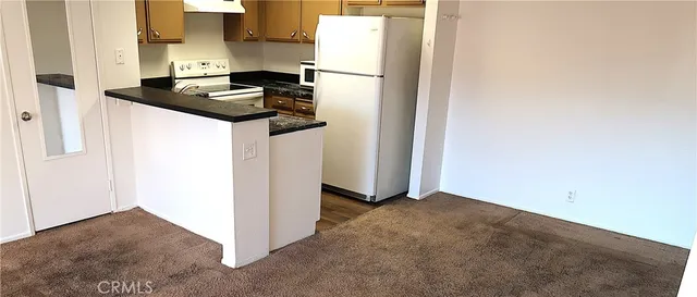 a white refrigerator freezer and a stove sitting inside of a kitchen