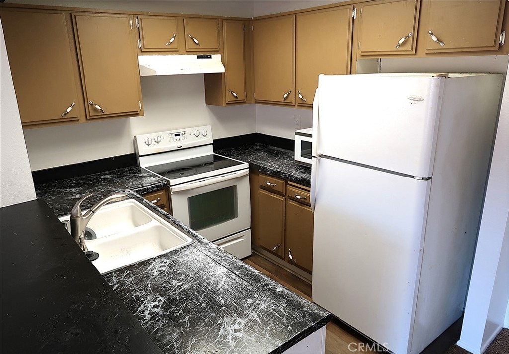 1440 West Edgehill Road, Unit 14 San Bernardino, CA 92405 - Photo 6 of 34 a white refrigerator freezer and a stove sitting inside of a kitchen