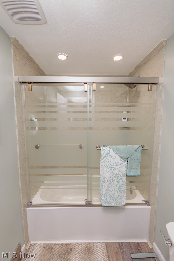 120 Sunset Road Avon Lake, OH 44012 - Photo 16 of 40 Bathroom featuring wood-type flooring, bath / shower combo with glass door, and toilet