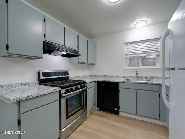 a kitchen with granite countertop cabinets stainless steel appliances and sink