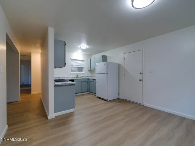 a view of kitchen with refrigerator and wooden floor