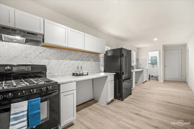 a kitchen with a stove a refrigerator and cabinets