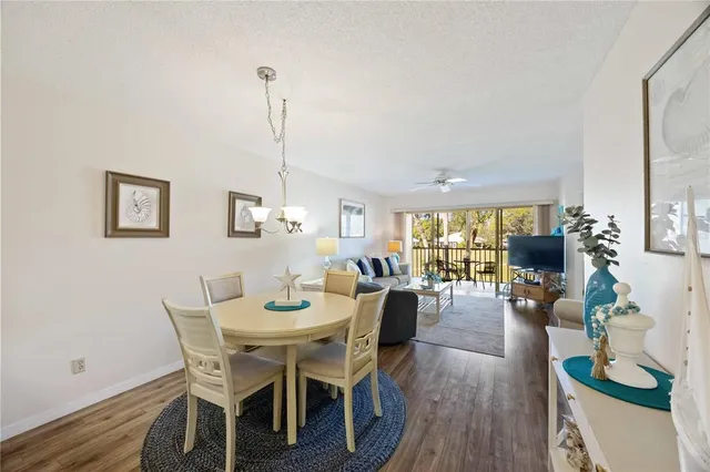 a dining room with furniture potted plants and wooden floor