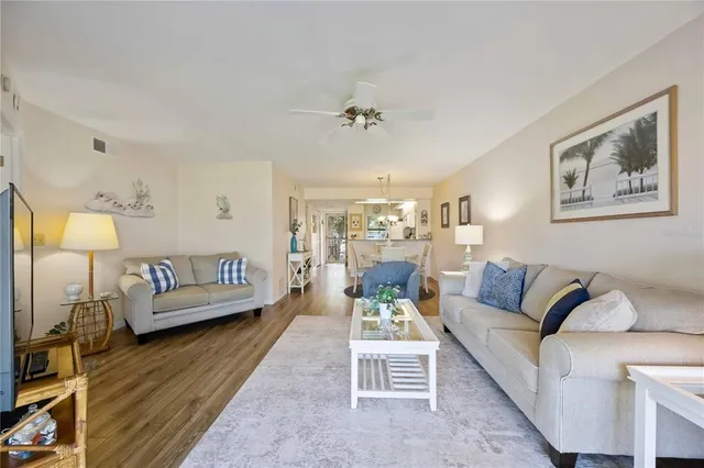 a living room with furniture kitchen view and a window