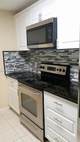 a stove top oven sitting inside of a kitchen