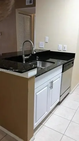 a close view of a sink and dishwasher with kitchen island