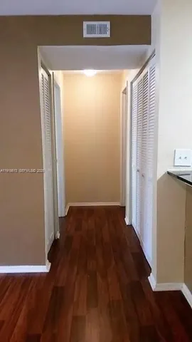 an empty room with wooden floor and a window