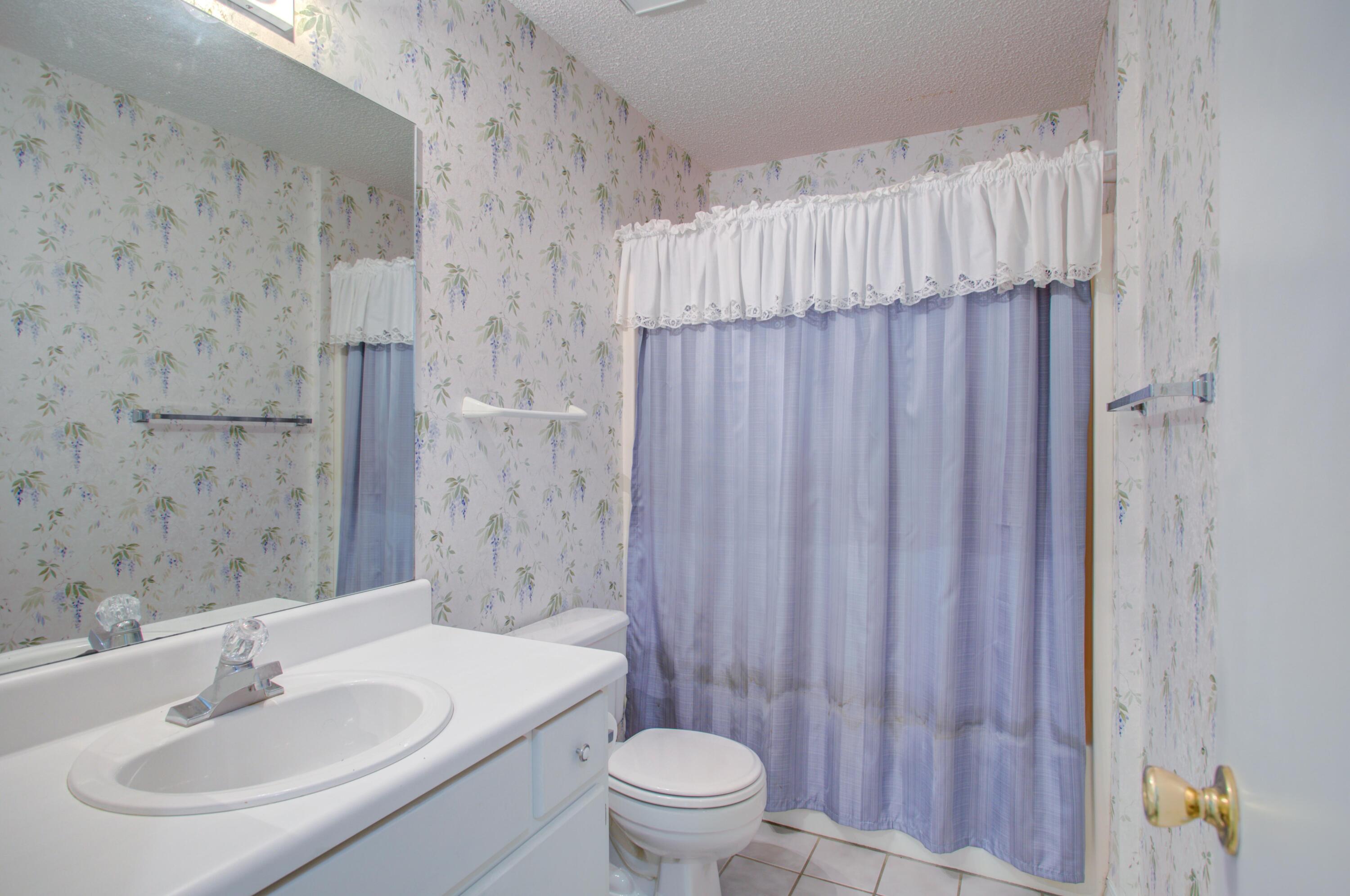 38 Ruby Circle Mary Esther, FL 32569 - Photo 12 of 16 a bathroom with a sink a toilet and shower curtain