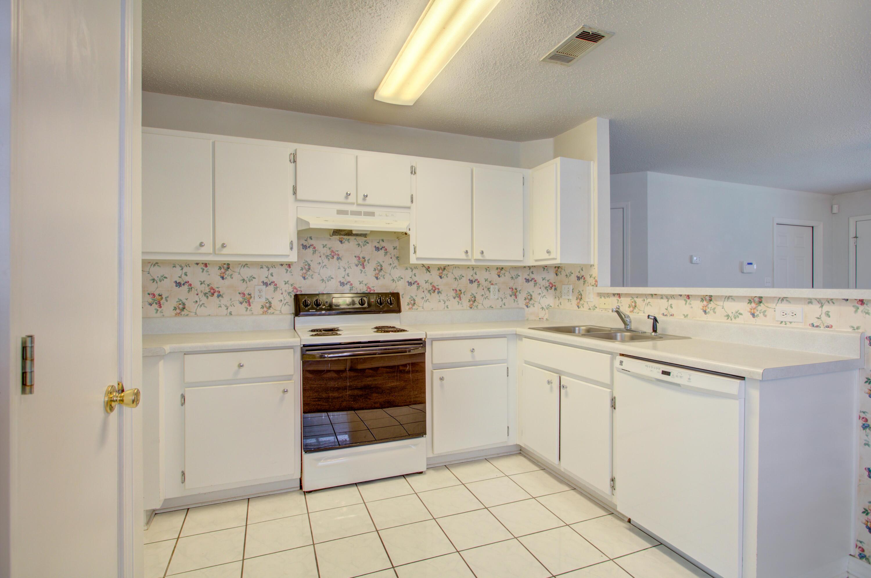 38 Ruby Circle Mary Esther, FL 32569 - Photo 3 of 16 a kitchen with granite countertop white cabinets and white appliances