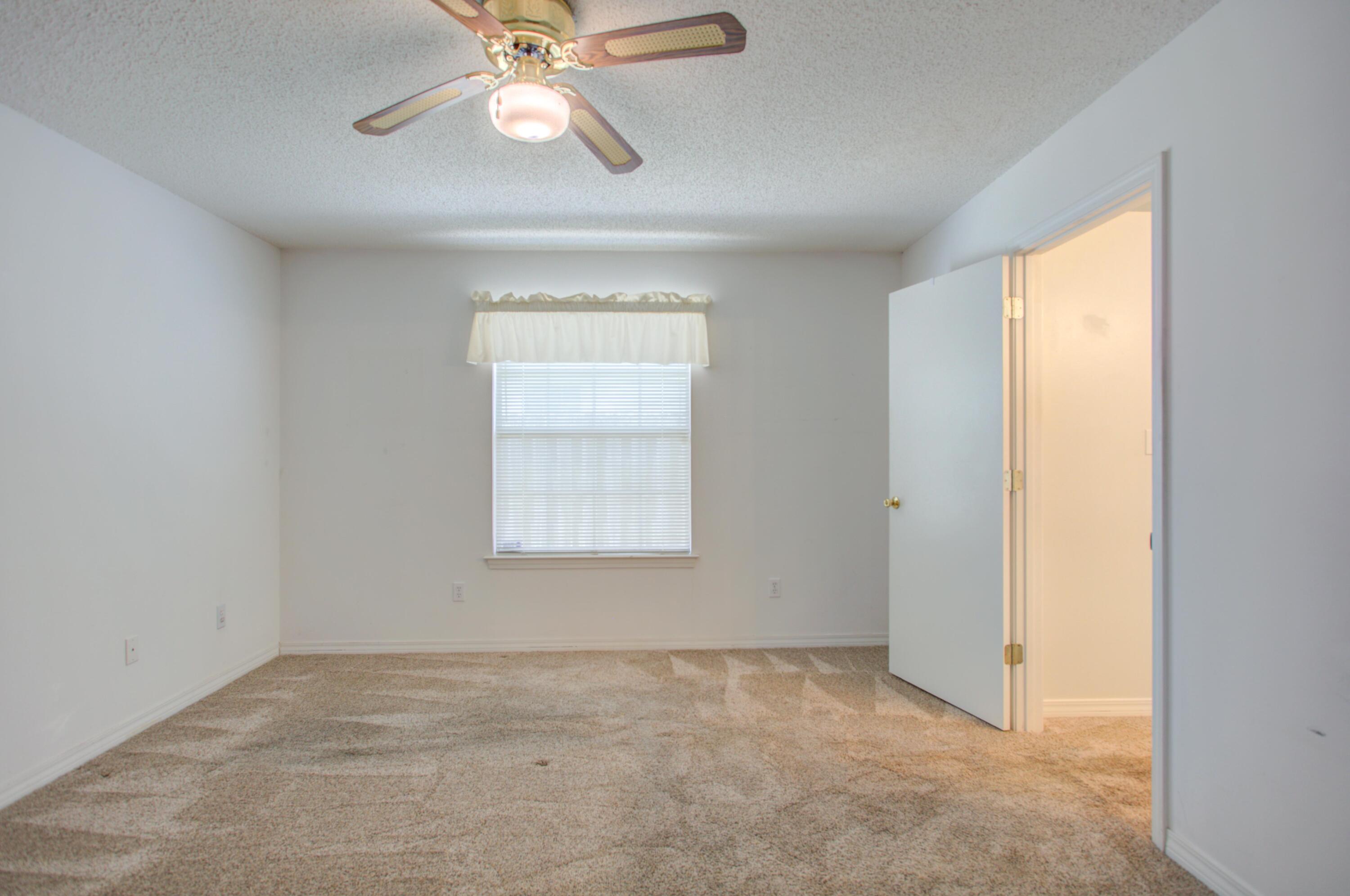 38 Ruby Circle Mary Esther, FL 32569 - Photo 9 of 16 an empty room with a chandelier fan and windows