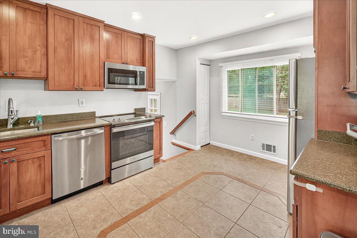 19808 Westerly Avenue Poolesville, MD 20837 - Photo 20 of 64 a kitchen with stainless steel appliances granite countertop a stove a sink and a microwave