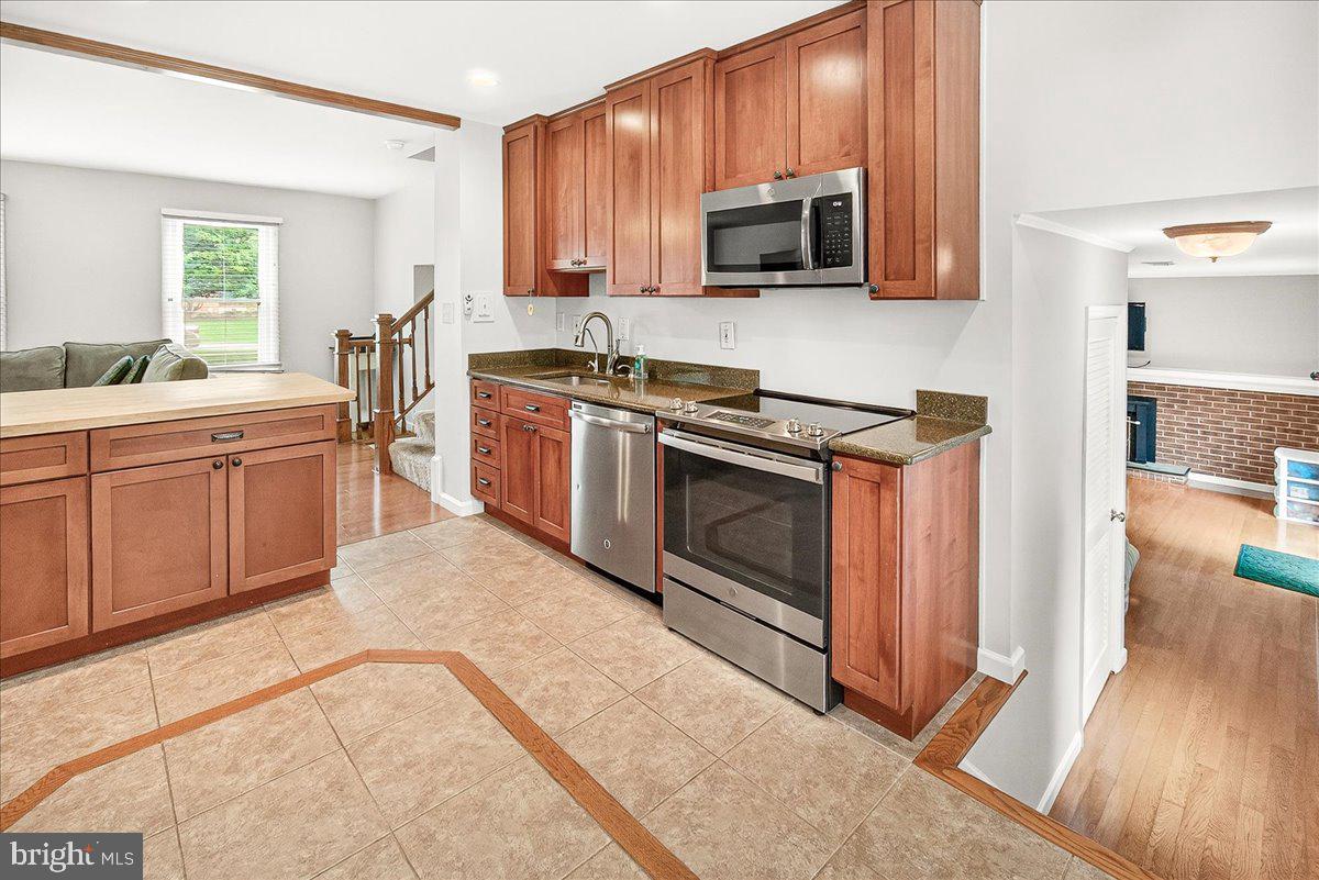 19808 Westerly Avenue Poolesville, MD 20837 - Photo 21 of 64 a kitchen with stainless steel appliances granite countertop a stove a sink and a microwave