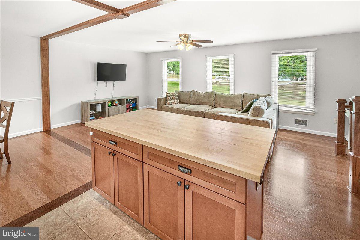19808 Westerly Avenue Poolesville, MD 20837 - Photo 22 of 64 a living room with stainless steel appliances kitchen island granite countertop a sink a stove and a wooden floors