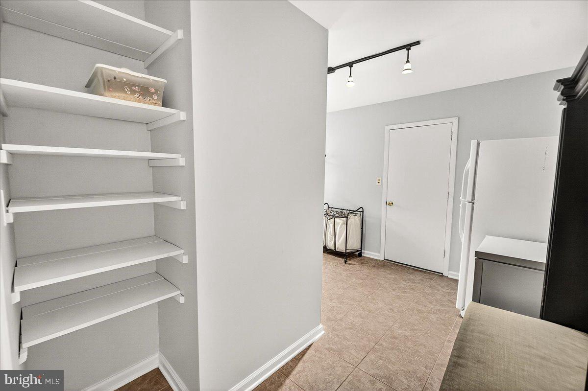 19808 Westerly Avenue Poolesville, MD 20837 - Photo 32 of 64 a view of an empty room with cabinet and a refrigerator