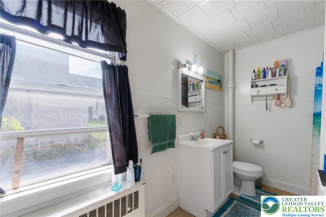 27 West Allen Street Allentown, PA 18102 - Photo 12 of 21 a bathroom with a toilet a sink and a mirror