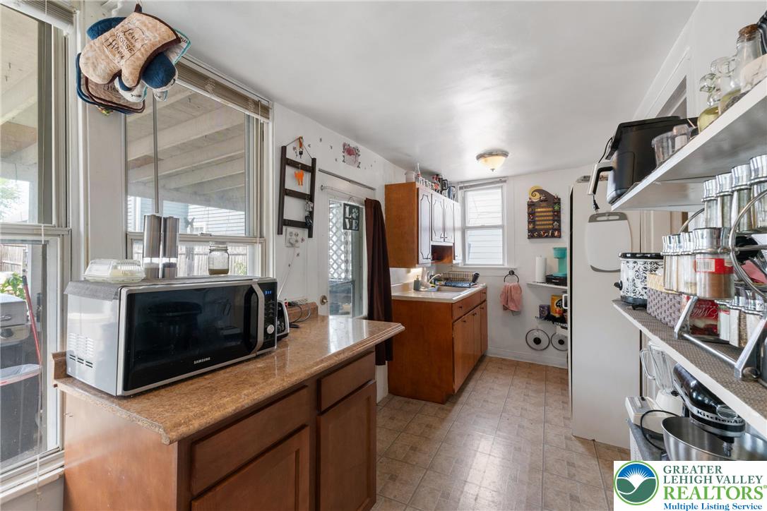 27 West Allen Street Allentown, PA 18102 - Photo 5 of 21 a kitchen with stainless steel appliances kitchen island granite countertop a stove a sink dishwasher and a fireplace with wooden floor