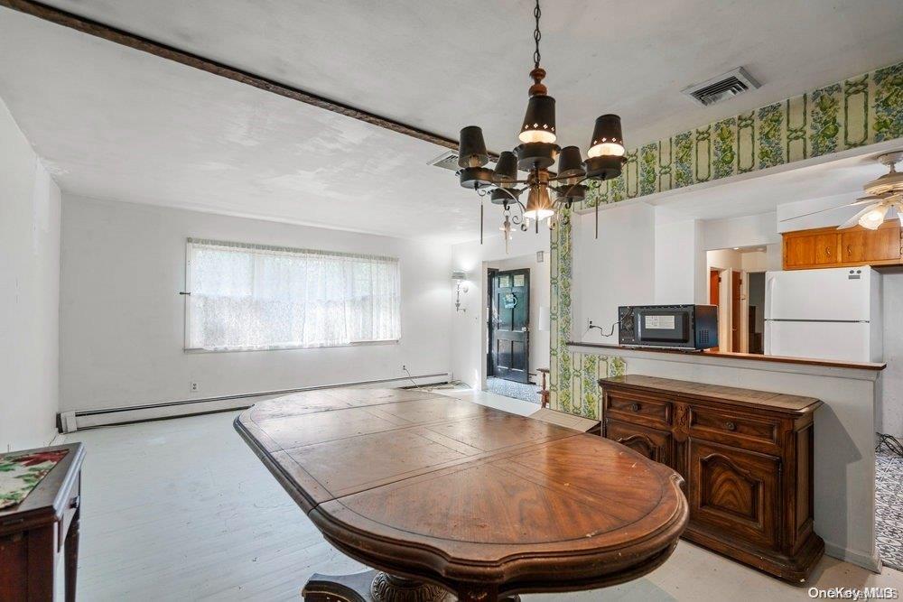 1931 Miller Place Merrick, NY 11566 - Photo 6 of 14 a dining room with fireplace and chandelier