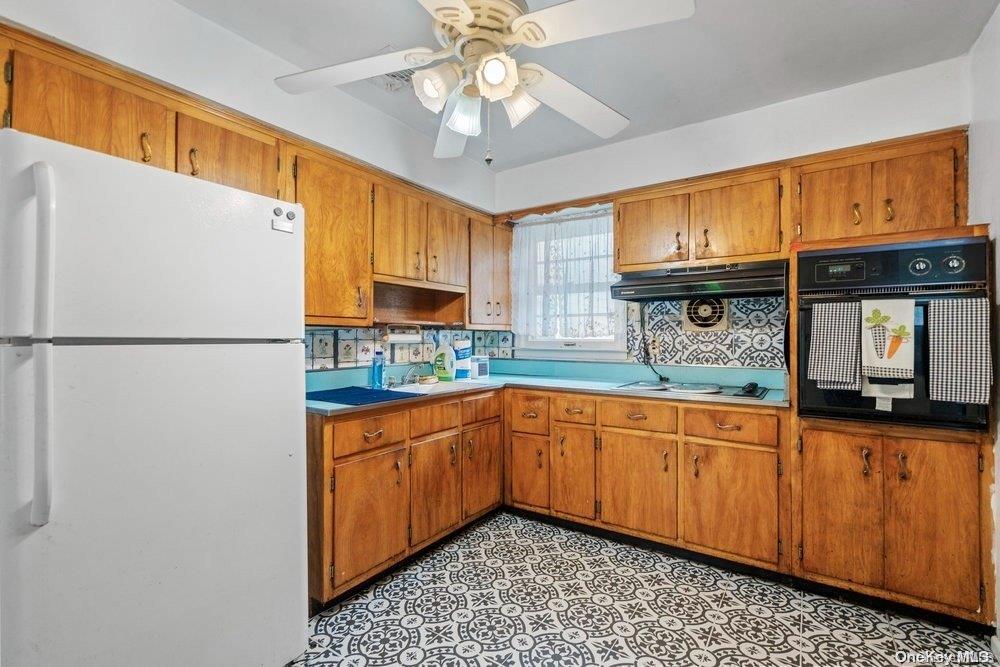 1931 Miller Place Merrick, NY 11566 - Photo 8 of 14 a kitchen with stainless steel appliances granite countertop a refrigerator a sink dishwasher a stove with wooden cabinets and dining table