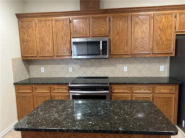 a kitchen with wooden cabinets and a stove top oven