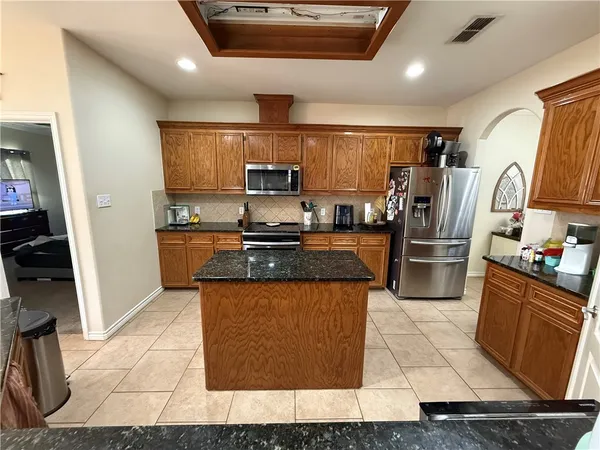 a kitchen with stainless steel appliances granite countertop a stove a sink and a refrigerator