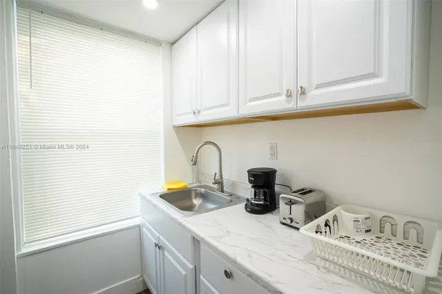 a bedroom with a bed and a flat tv screen on a dresser