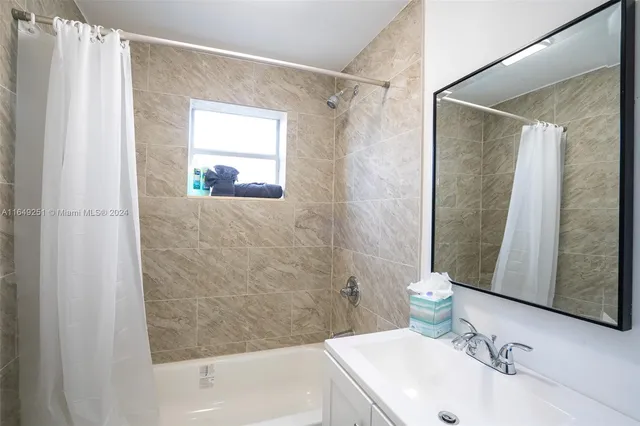 a bathroom with a tub a sink and a window
