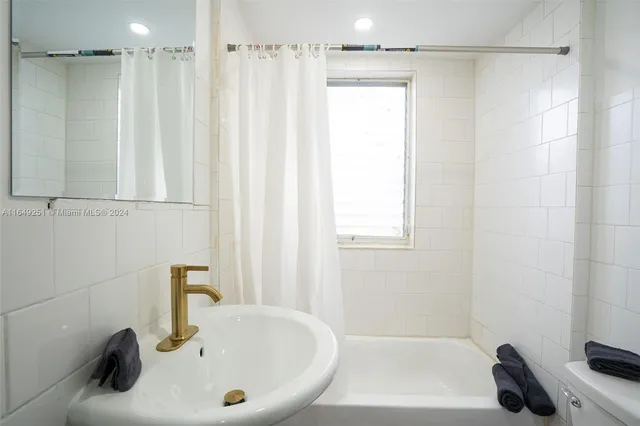 a bathroom with a sink mirror and a shower